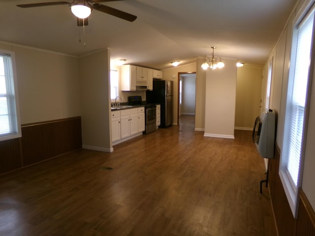 kitchen featuring dark wood-style floors, freestanding refrigerator, heating unit, stainless steel range with electric stovetop, and a sink