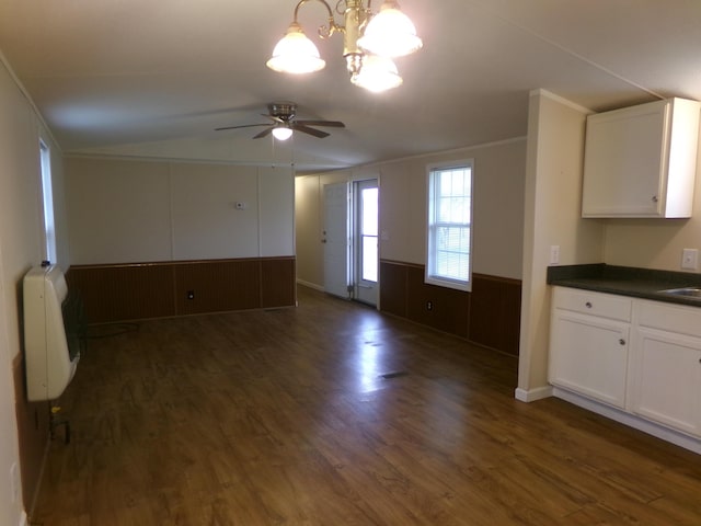 interior space with lofted ceiling, dark wood-style floors, ceiling fan, heating unit, and crown molding