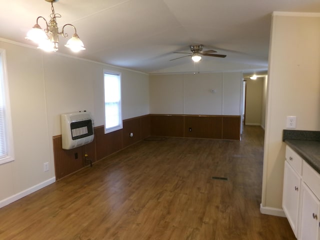 kitchen with a wainscoted wall, heating unit, dark countertops, white cabinetry, and wood finished floors