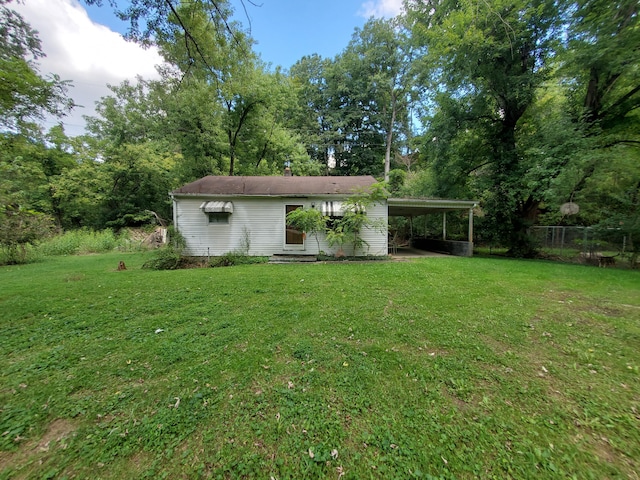 exterior space with a carport and a yard