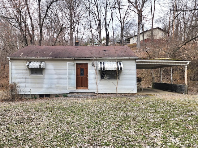 back of property with a carport