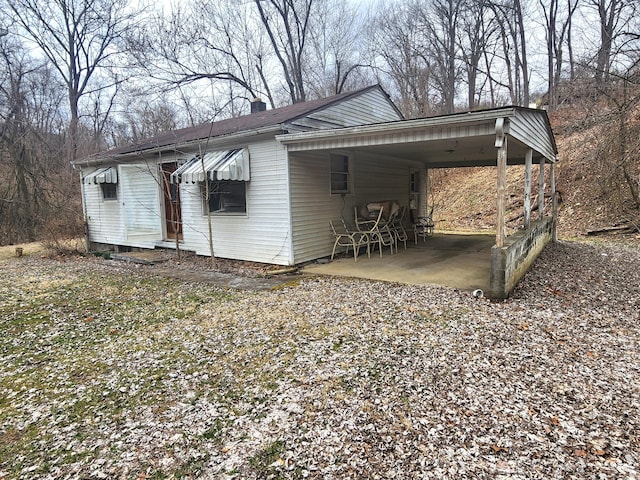 view of outdoor structure with driveway and an attached carport