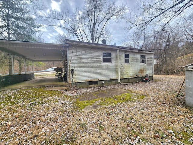 back of property with an attached carport