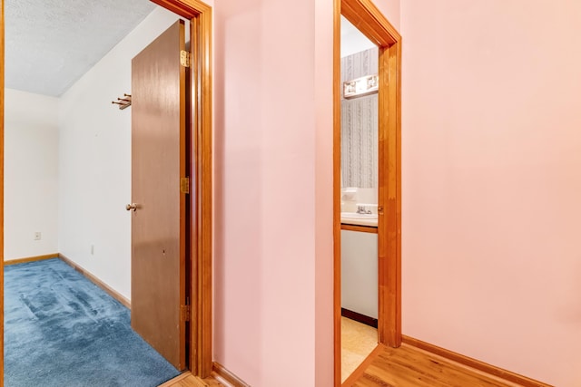 hallway with baseboards and a sink