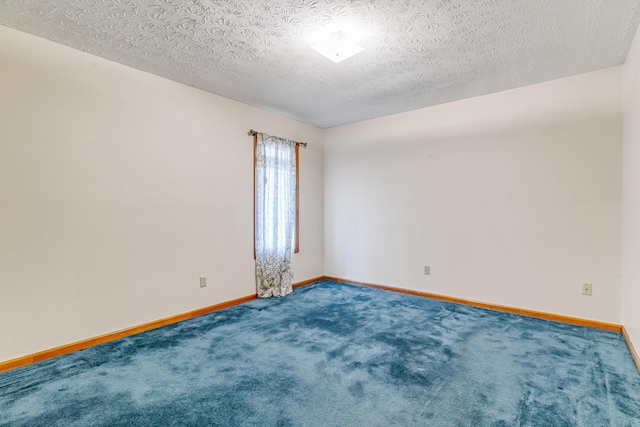 unfurnished room featuring a textured ceiling, carpet, and baseboards