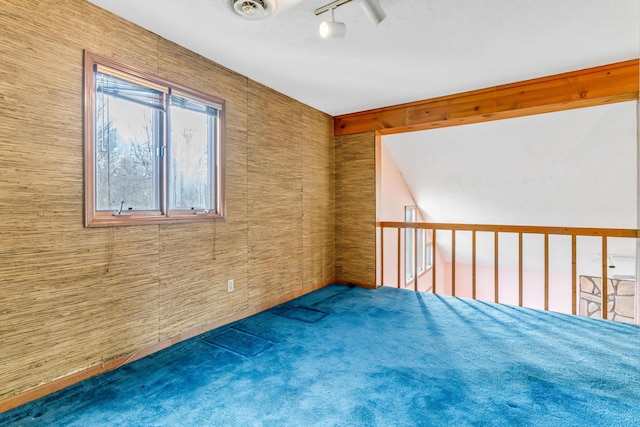 carpeted empty room with visible vents and track lighting