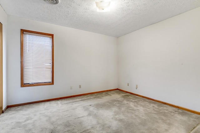 empty room featuring a textured ceiling, baseboards, and carpet flooring