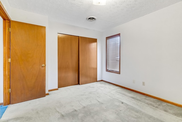 unfurnished bedroom featuring a closet, carpet flooring, visible vents, and baseboards