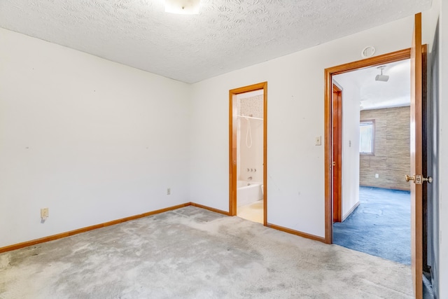 unfurnished room with carpet, a textured ceiling, and baseboards