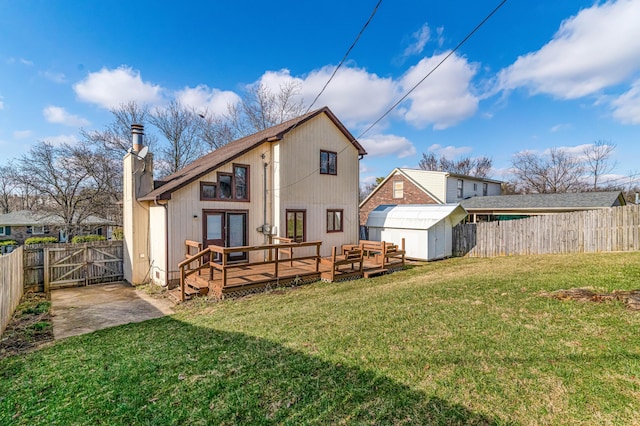 back of property featuring an outbuilding, a fenced backyard, a storage shed, a lawn, and a gate