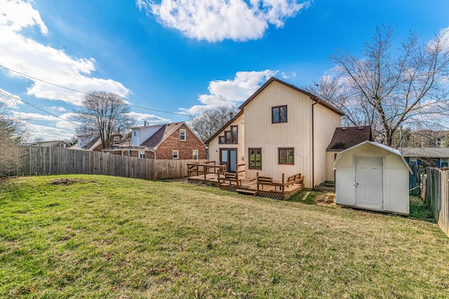 back of house with a fenced backyard, an outbuilding, a yard, a wooden deck, and a shed