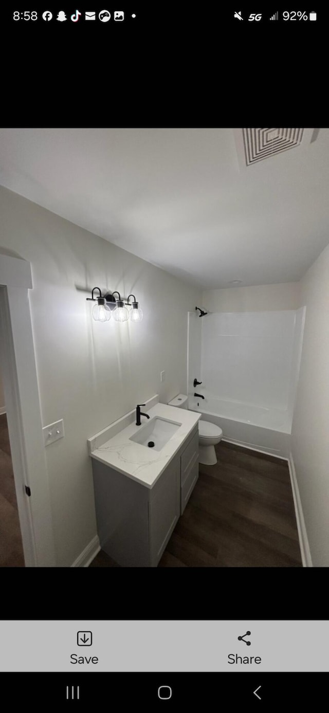 full bathroom with visible vents, toilet, wood finished floors, bathtub / shower combination, and vanity