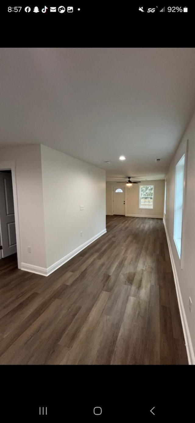 unfurnished living room with dark wood-style floors, recessed lighting, a ceiling fan, and baseboards