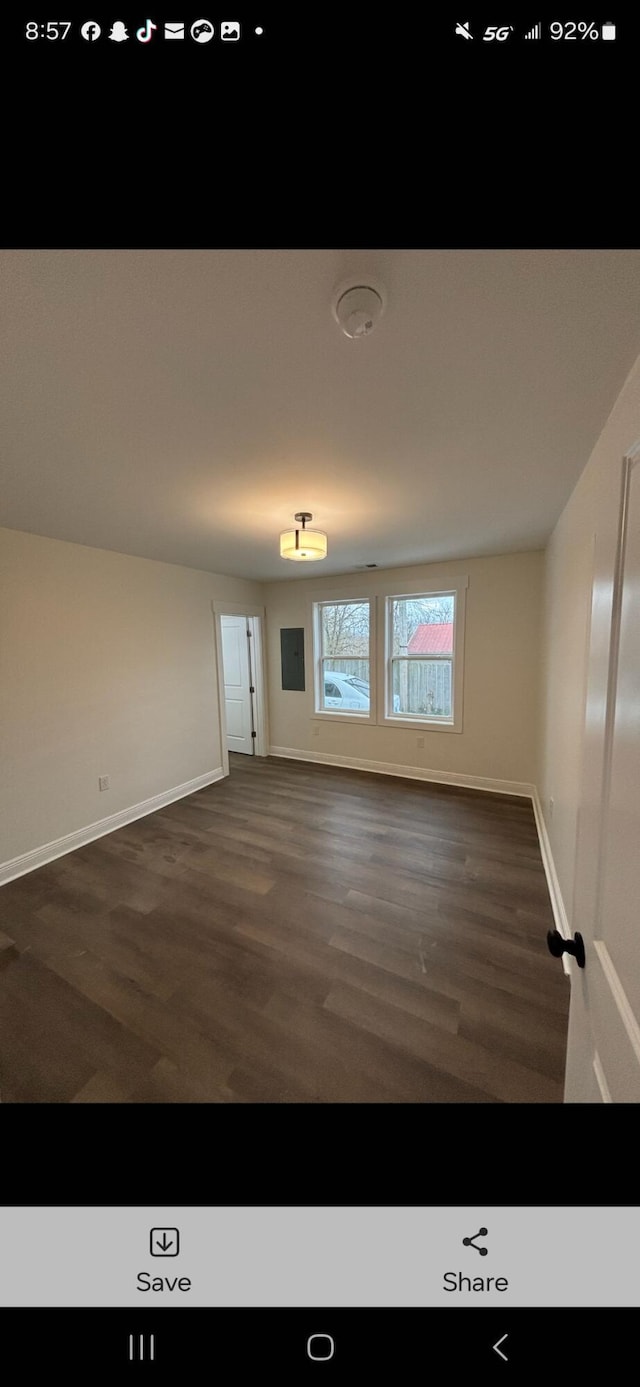 empty room featuring dark wood-style floors and baseboards