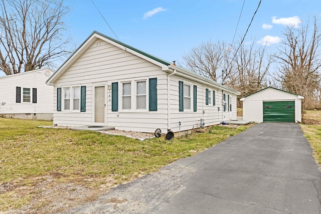 bungalow-style house featuring a front lawn, an outdoor structure, a detached garage, and aphalt driveway