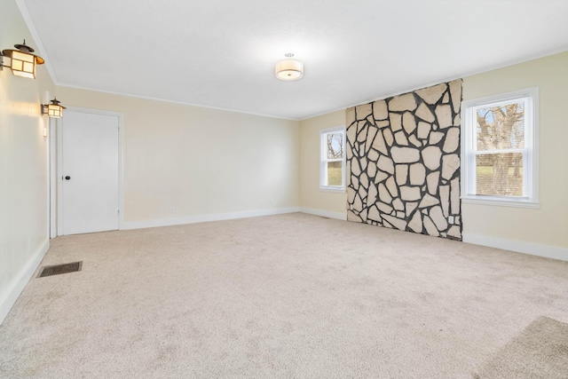 spare room featuring ornamental molding, carpet, visible vents, and baseboards