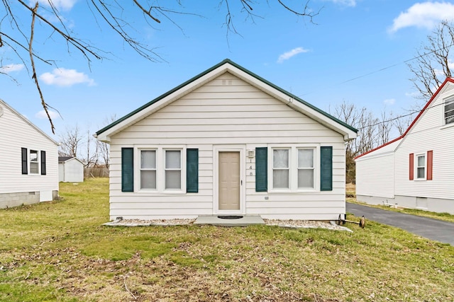 bungalow-style home featuring driveway and a front lawn