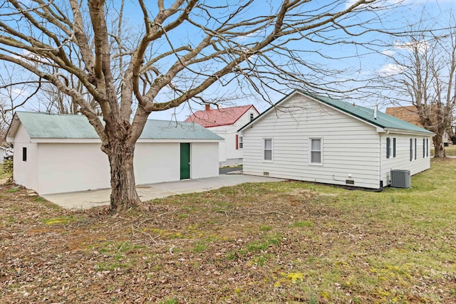 back of house featuring a patio area, a lawn, cooling unit, and an outbuilding