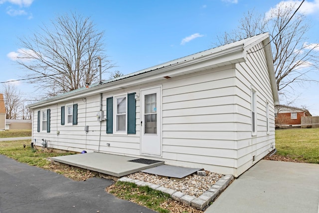 view of front of property featuring metal roof and a front lawn