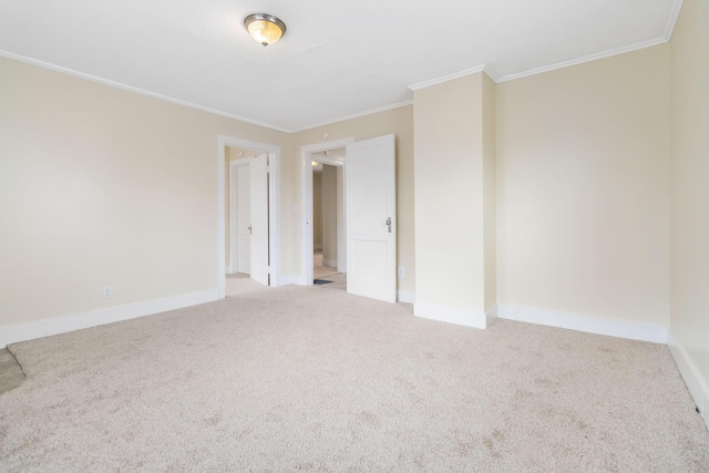 carpeted empty room with baseboards and crown molding