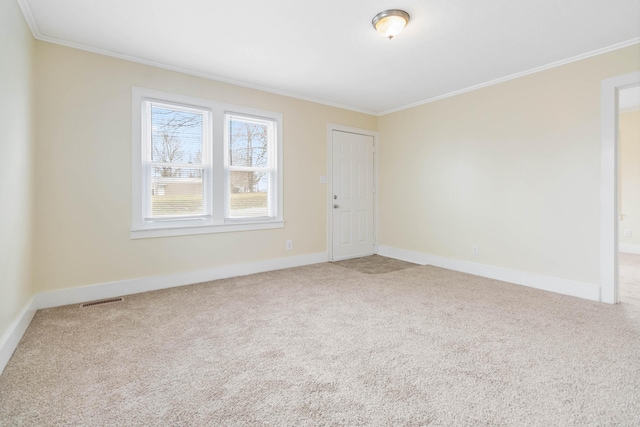 unfurnished room with carpet floors, visible vents, ornamental molding, and baseboards