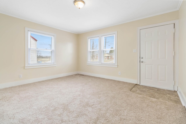 spare room featuring carpet floors, baseboards, and ornamental molding