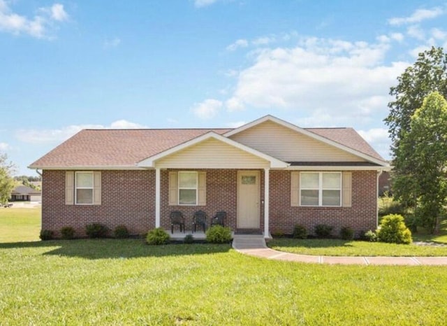 ranch-style house featuring brick siding and a front lawn