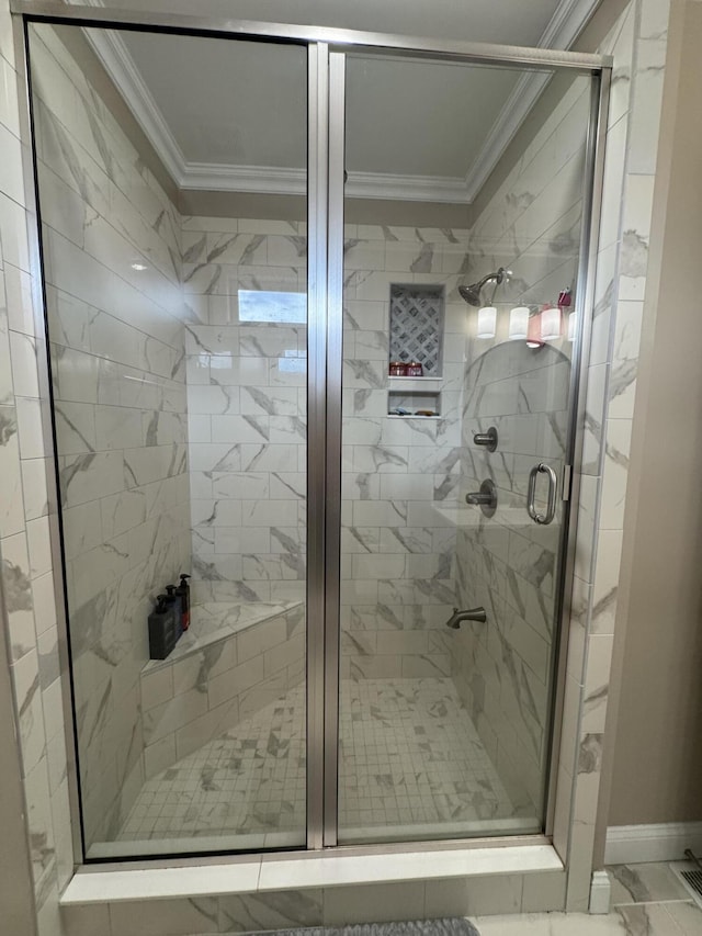 bathroom with marble finish floor, ornamental molding, and a shower stall