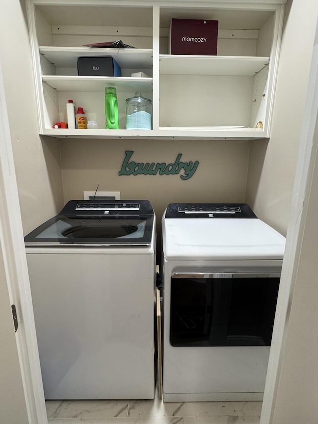 clothes washing area featuring marble finish floor, laundry area, and independent washer and dryer