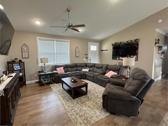 living room with lofted ceiling, ceiling fan, light wood finished floors, and baseboards