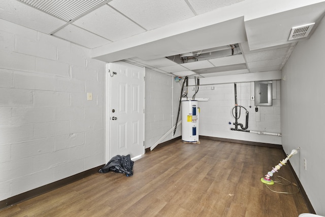 finished basement featuring concrete block wall, visible vents, electric water heater, wood finished floors, and electric panel