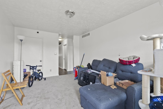 carpeted living area with visible vents and a textured ceiling