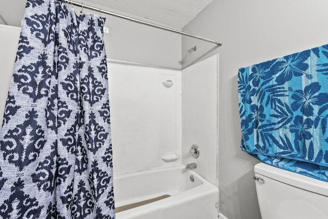 bathroom featuring a textured ceiling, shower / tub combo, and toilet