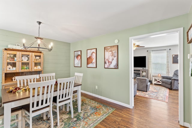 dining space with an inviting chandelier, wood finished floors, and baseboards