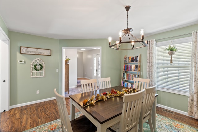 dining area with visible vents, baseboards, and wood finished floors