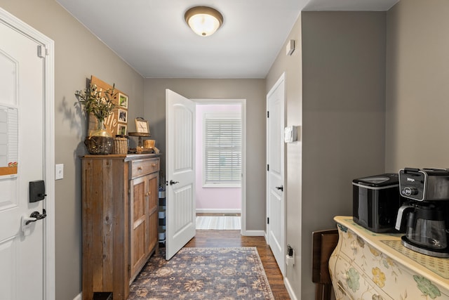 foyer with dark wood-type flooring and baseboards