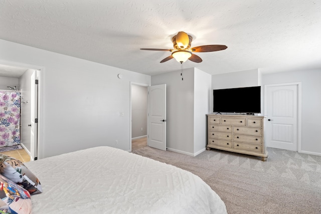 bedroom with a textured ceiling, a ceiling fan, baseboards, and light carpet