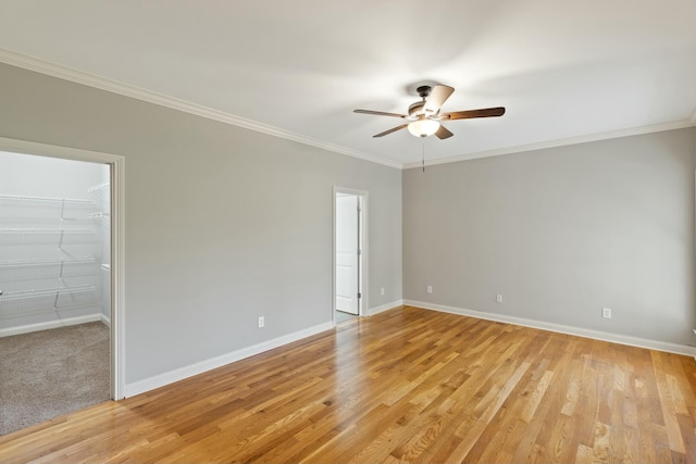 unfurnished room featuring ornamental molding, light wood-style floors, and baseboards