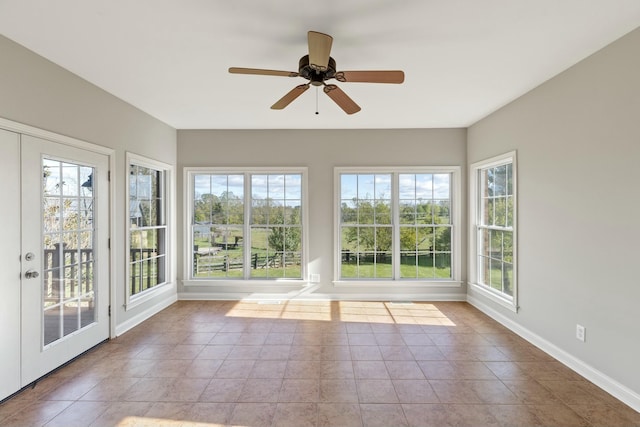 unfurnished sunroom with a ceiling fan