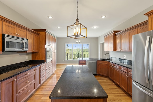 kitchen with light wood-style flooring, a kitchen island, stainless steel appliances, a sink, and recessed lighting