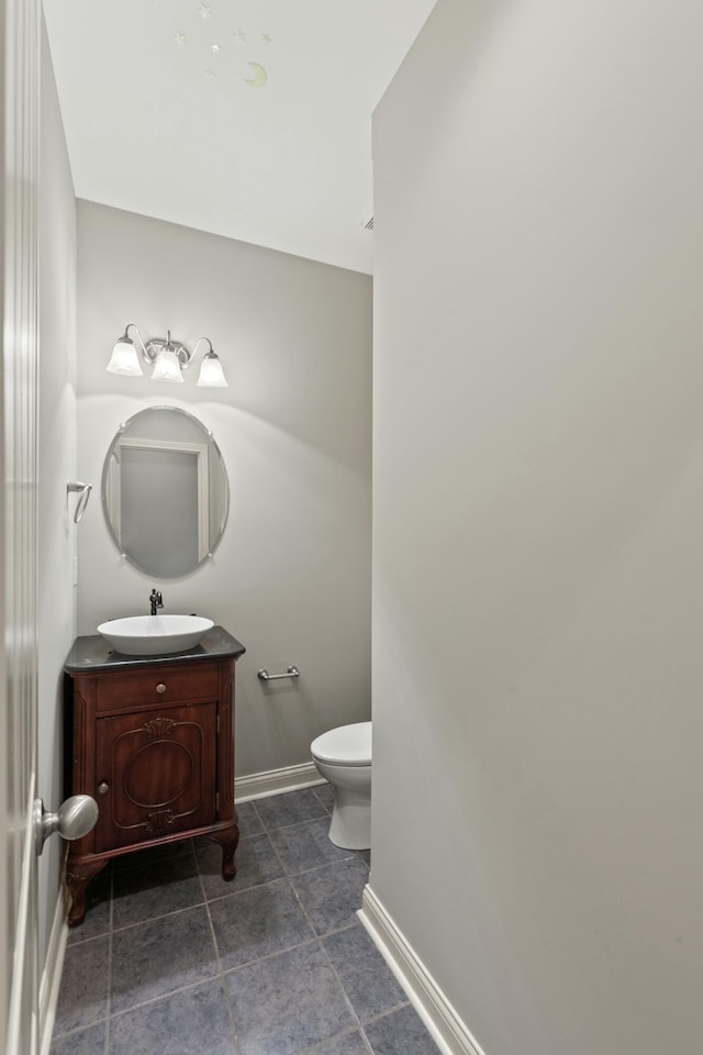 bathroom featuring baseboards, vanity, and toilet