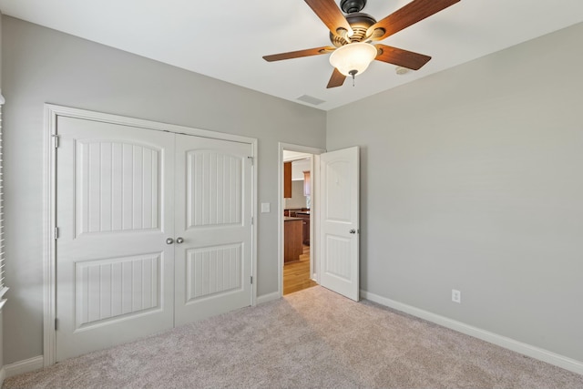 unfurnished bedroom with light carpet, a ceiling fan, visible vents, baseboards, and a closet