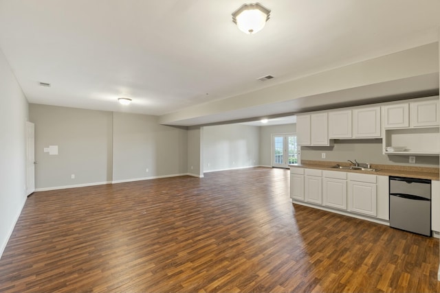 kitchen featuring a sink, white cabinets, open floor plan, dishwasher, and dark wood finished floors