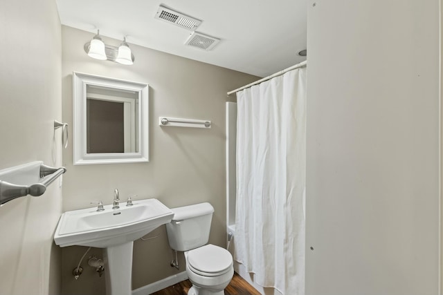 full bathroom featuring toilet, a sink, visible vents, and baseboards