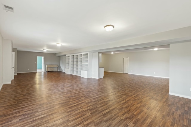 unfurnished living room featuring dark wood-style floors, visible vents, and baseboards