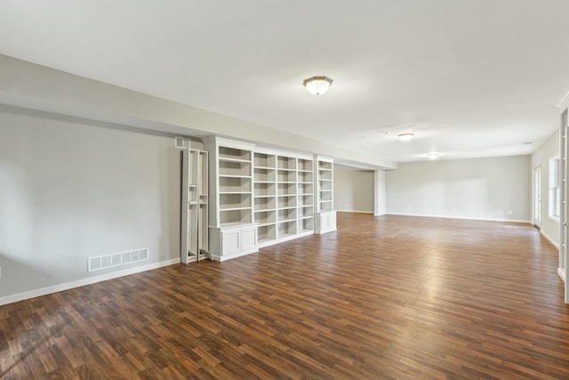 spare room featuring wood finished floors, visible vents, and baseboards