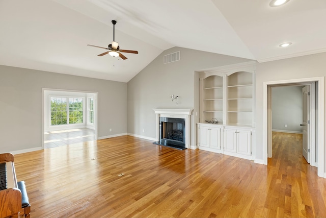 unfurnished living room with a fireplace, lofted ceiling, light wood-style floors, ceiling fan, and baseboards