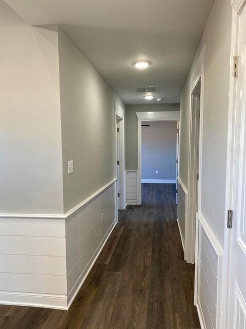 corridor featuring dark wood-type flooring and visible vents