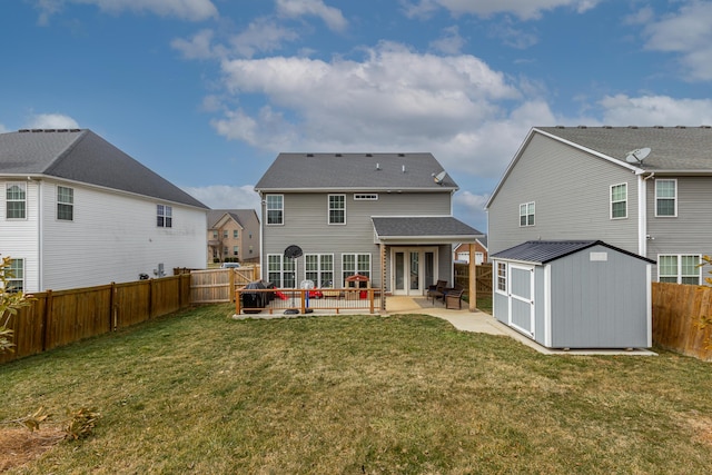 rear view of house with an outbuilding, a patio, a fenced backyard, a lawn, and a shed