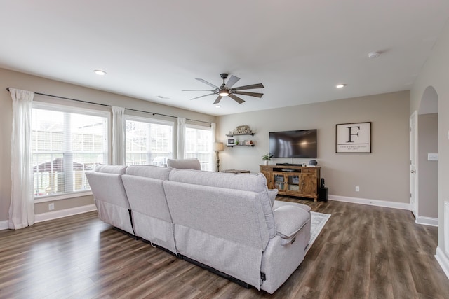 living area with dark wood-style floors, baseboards, arched walkways, and recessed lighting